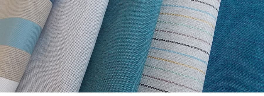 Various textured fabric swatches in shades of blue and beige with solid and striped patterns.
